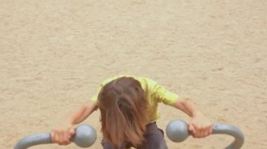 Şehir parkında egzersiz simülatörü yapan aktif bir genç. Bedava vücut egzersizi.