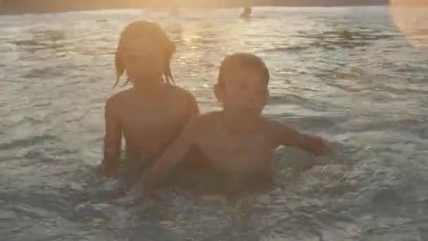 Niños felices nadan en el mar, abrazos. Los niños descansan durante las vacaciones de verano. — Vídeos de Stock