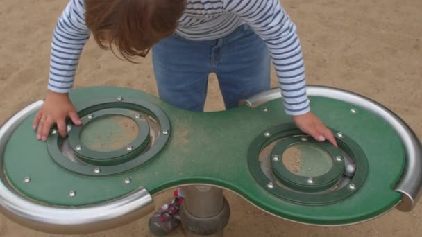 Criança síndrome de Down brinca. Necessidades especiais equipamentos de playground ao ar livre. — Vídeo de Stock