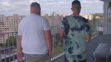 Balkonda bir fincan kahveyle neşeli iki adam. Yeni güne başla. 