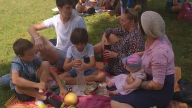 Piknik için boş zamanlarında çocuklar arkadaşlarıyla neşeli kucaklaşır parkta piknik yaparlar.