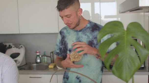 Man voegt noten smoothie partner besteden tijd in keuken begin dag. — Stockvideo