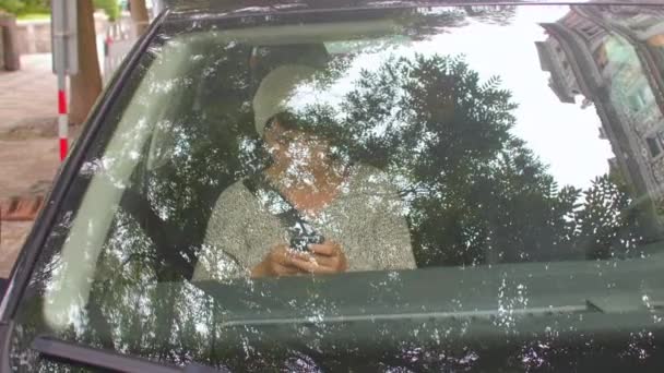 Una mujer pasajera está sentada en la cabina de un coche, está usando un teléfono inteligente. — Vídeos de Stock