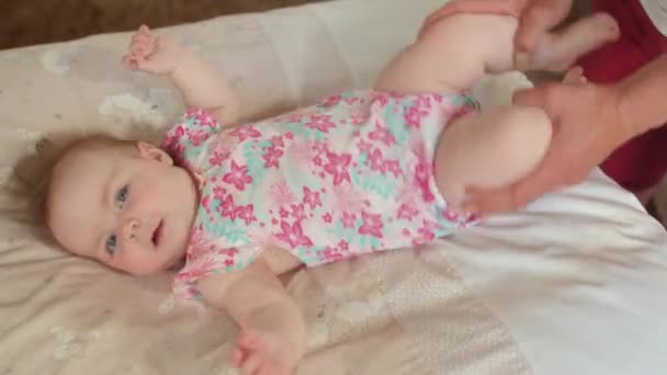 Ebeveynler küçük bir bebeğe el masajı yapar, bacak egzersizleri yapar.. — Stok video