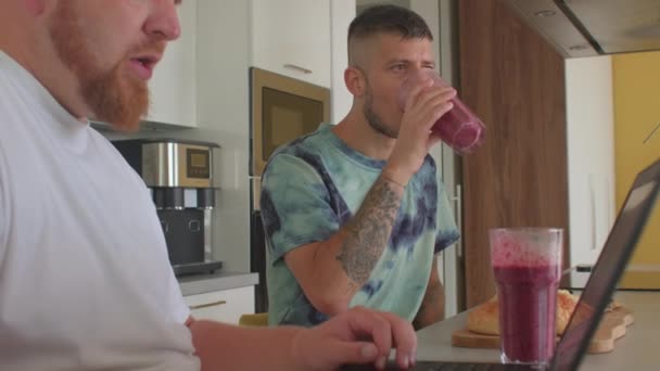 Man trinkt einen Frucht-Smoothie während des Frühstücks in der heimischen Küche. Vitamindiät. — Stockvideo