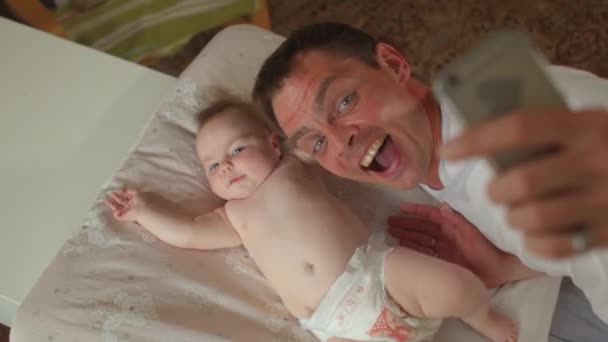 Bebé recién nacido con padre feliz. Utilice el teléfono durante la videollamada. — Vídeos de Stock
