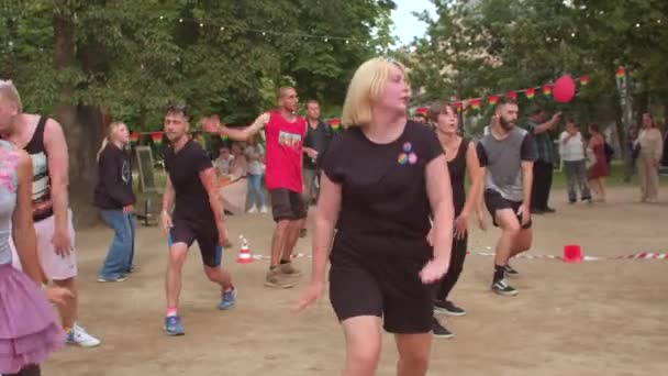 Groepsoefening in stadspark meisjes verplaatsen hun lichaam naar de beat van de muziek — Stockvideo