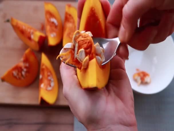 Technology of cleaning pumpkin from seeds with spoon, cooking in the kitchen. — Stock Video