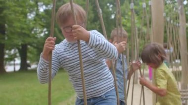 Down sendromlu çocuk engelli ipin üzerinden atlıyor, el ele tutuşuyor, mahkemeyi hareket ettiriyor..