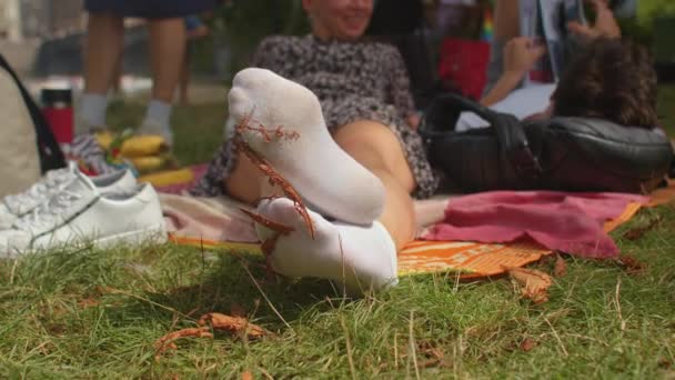 Füße in weißen Socken einer jungen Frau, die im Park ruht. Fußanbetung als Fetisch. — Stockvideo