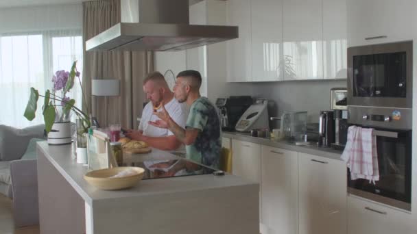 Echt schwuler Mann bietet seiner Geliebten Brötchen zum Frühstück zu Hause an. Auf Ernährung achten. — Stockvideo