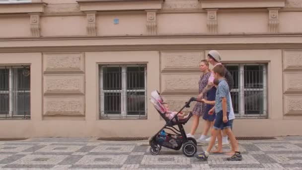 Mulheres com carrinho e crianças caminham ao longo da rua deserta em uma cidade europeia. — Vídeo de Stock