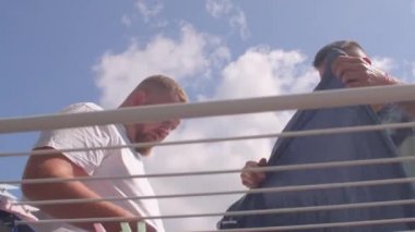 Eşcinsel bir çift kuruması için balkona çamaşır asıyor.