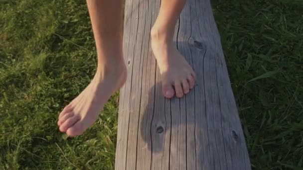 Děti bosé chodí po dřevěné kládě. Výhoda chůze bosá. — Stock video