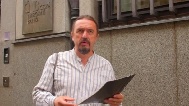 Hombre habla de un documento archivado en un banco en la República Checa — Vídeos de Stock