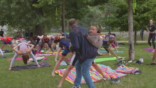 Gruppo di persone che fanno yoga parco della città. Tengono asana, aumentano il tono muscolare del corpo — Video Stock