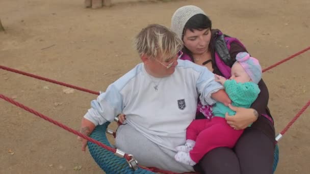 Uma mulher deficiente em conjunto com uma mãe e um filho. — Vídeo de Stock