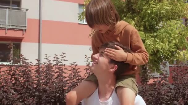 Guy with a preteen kid. Smiling young daddy carrying excited son, having fun. — Stock Video