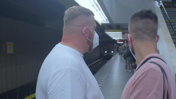 지하철 터널에서 열차를 기다리고 있는 두 사람의 얼굴 마스크는 먼지와 먼지로부터 보호 한다 — 비디오