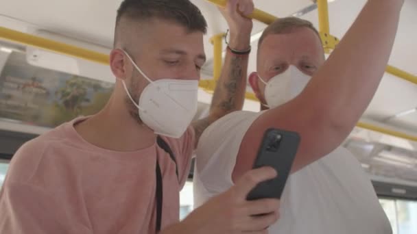 Uomo mascherato utilizza tram telefono Sembra schermo dello smartphone, rende video osare sociale — Video Stock