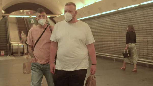 Человек в маске на вокзале. Они двигаются в туннель. Он держит сумку в руках.. — стоковое фото