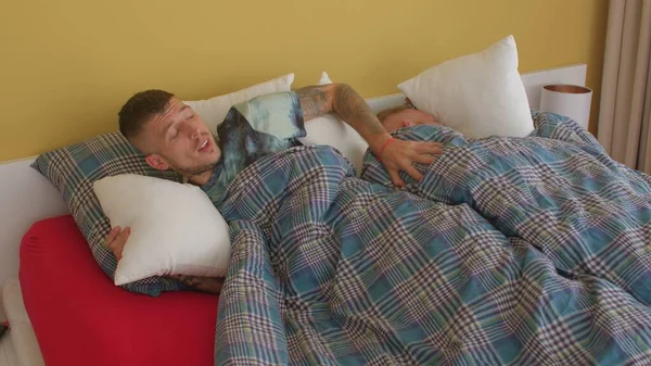 Um homem a dormir abraçado na cama. Amor LGBT. Casual sexo aceitação entre homens gays. — Fotografia de Stock