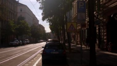 Şehirde güneşli bir cadde. Tramvay izleri asfalta indirilmiş.. 