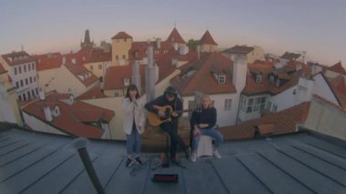 Açık hava reçel seansı, balık gözü lensi. Gençler çatıda oynar ve şarkı söyler.. 