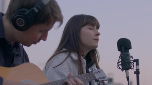 Menina de olhos fechados cantando em um microfone. A cantora feminina inspirada. — Vídeo de Stock