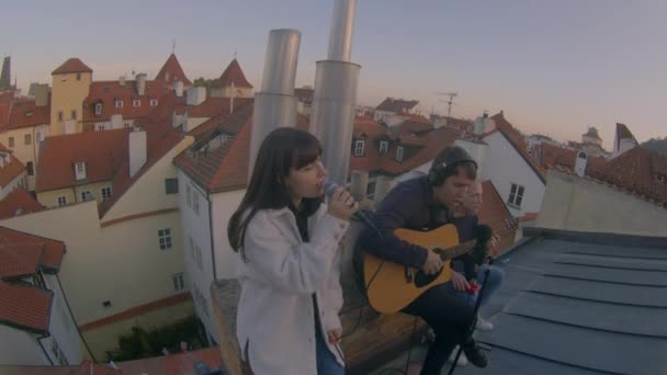 Los jóvenes cantan en el techo de la vieja ciudad europea. Humor romántico, amor. Ojo de pez. — Vídeos de Stock