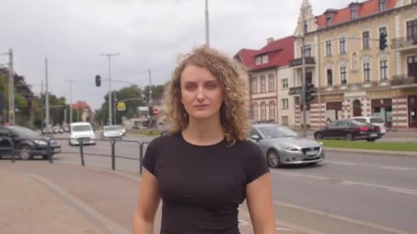 Портретна дівчина біля дороги в місті Машини їде на задньому плані.. — стокове відео