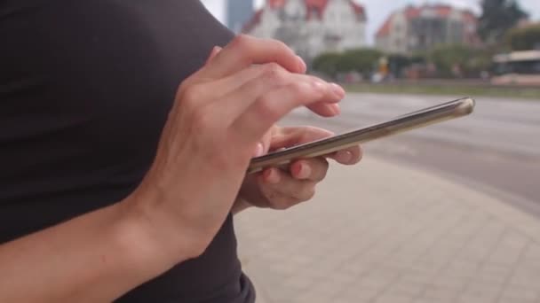 Kvinnan använder en mobiltelefon i händerna gatan. Lockigt blont hår. — Stockvideo