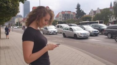 Şehirdeki cep telefonunu kullanarak. Bir kadın seyahat için bedava araba arıyor.. 