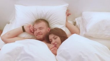 Düğün gecesinden sonra yeni evlilerin tatlı bir şekilde uyanması, sevgiyle iletişim kurması.