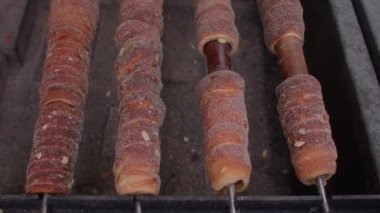 Ahşap bir çubukta sokak yemeği Trdelnik. Açık kömürde pişmiş hamur ve şeker..