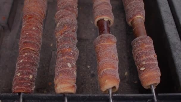 Utcai kaja trdelnik egy fa bottal. Sült tészta nyitott szénen cukorban. — Stock videók