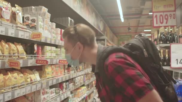Mann wählt Warenhausregal Maske Gesicht Atemschutz öffentlicher Ort — Stockvideo