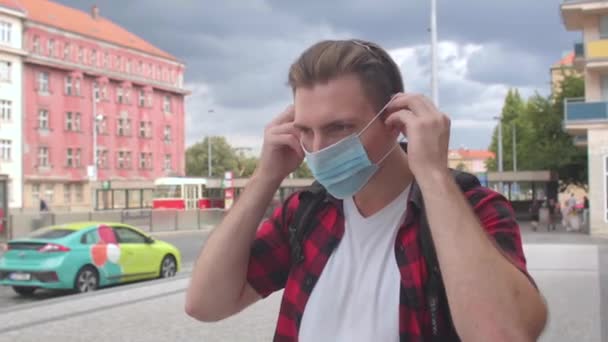 男はマスク顔の街を置く公共の場所での呼吸保護の尊重 — ストック動画