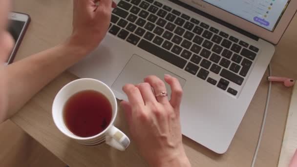 Mujer freelancer utiliza mesa portátil. Presiona el teclado, se desplaza en el monitor. — Vídeos de Stock