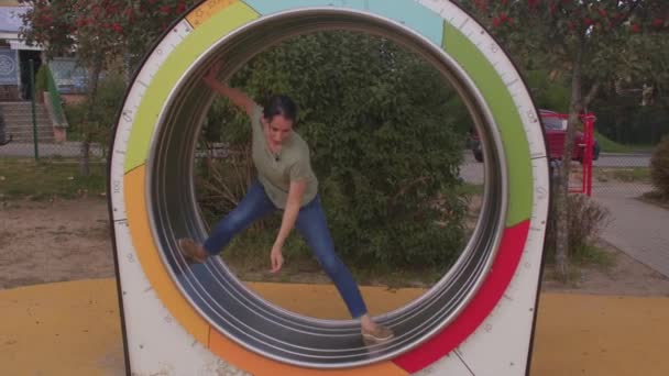 Una mujer está montando una rueda grande en la pista. Equilibra el cuerpo en movimiento — Vídeos de Stock