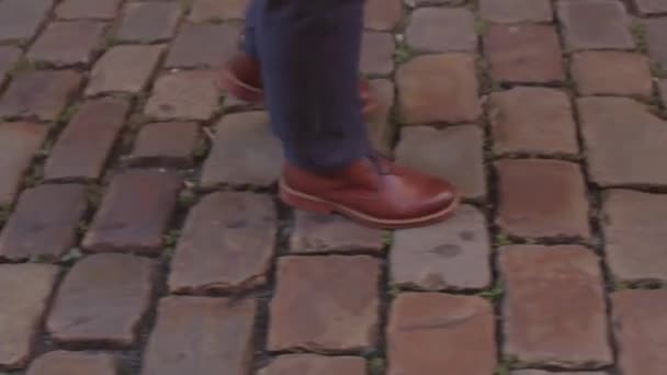 Movimento di attività fisica dei piedi, ciottoli nel centro storico. Scarpe uomo in pelle. — Video Stock