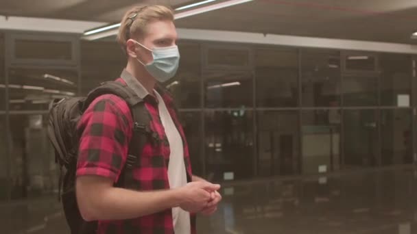 Ung fyr i en maske på hans ansigt giver en kommentar til karantæneforanstaltningerne. – Stock-video