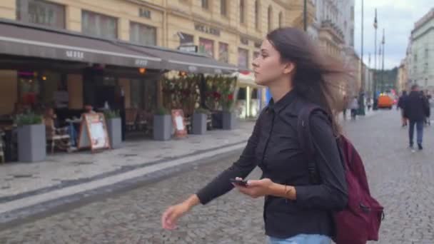 Mladá dívka používá svůj telefon k navigaci turistické trasy starého evropského města — Stock video