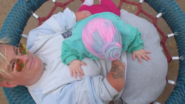 赤ちゃんと一緒にスイングの障害のある女性.子供と親. — ストック動画