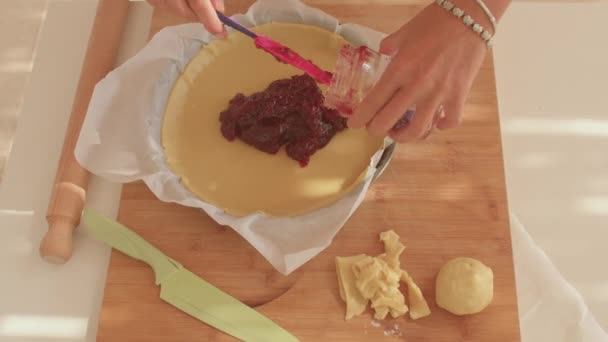 Egy rózsaszín spatula pirosat szór a tészta aljára sütés előtt. Jam torta Olaszországban. — Stock videók