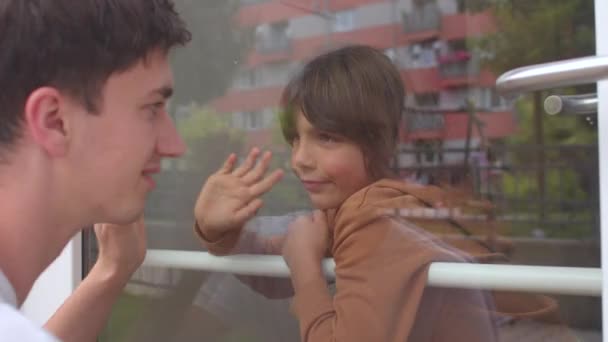 Family members communicate through glass during quarantine due to illness. — Vídeo de Stock