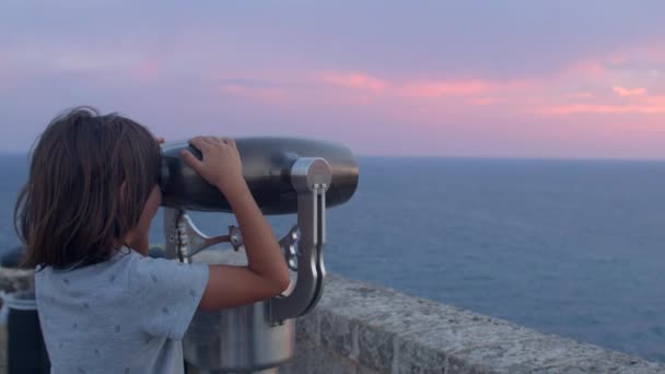 Child looks at the sea with binocular vending machine. Travel business for fun. — Video Stock