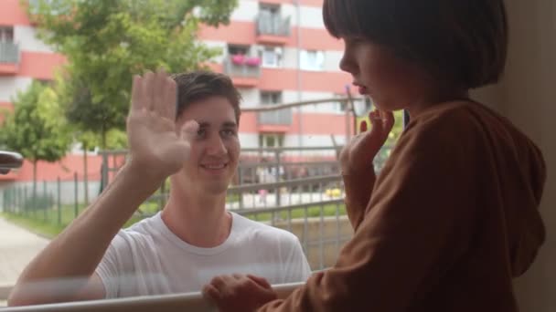 Члены семьи общаются через стекло во время карантина из-за болезни. — стоковое видео
