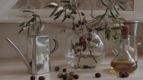Şeffaf vazoda zeytin dalları, masada zeytinyağı. — Stok video