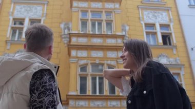 Turist adam ve bir kız binanın mimari cephesini tartışıyorlar..